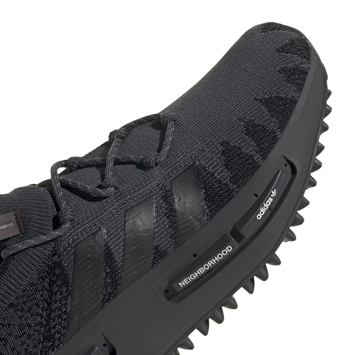 Black adidas NMD_S1 knit trainer close-up with laces and heel-side branding