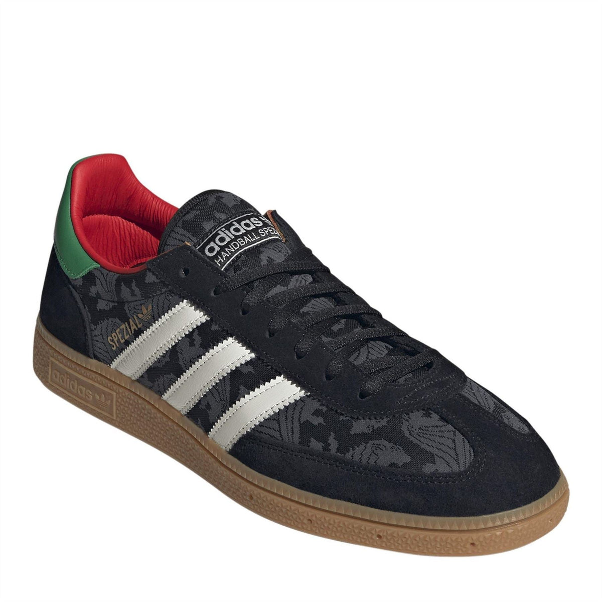 Black lace-up trainers with white three stripes, red and green collar, gum sole