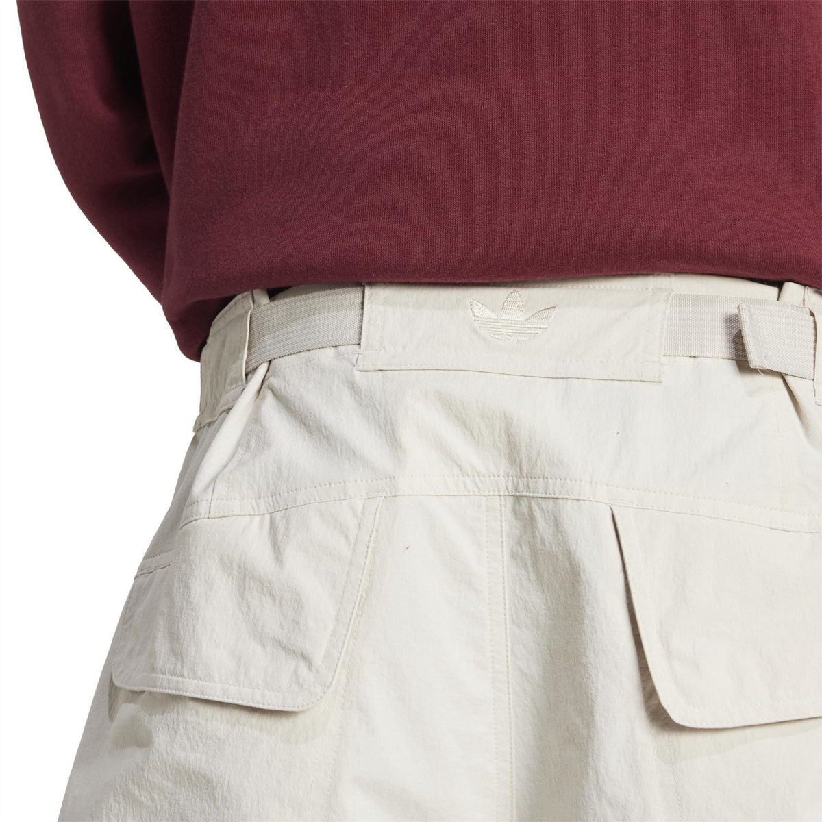 Light off-white shorts close-up of front pockets and adidas-style logo on waistband