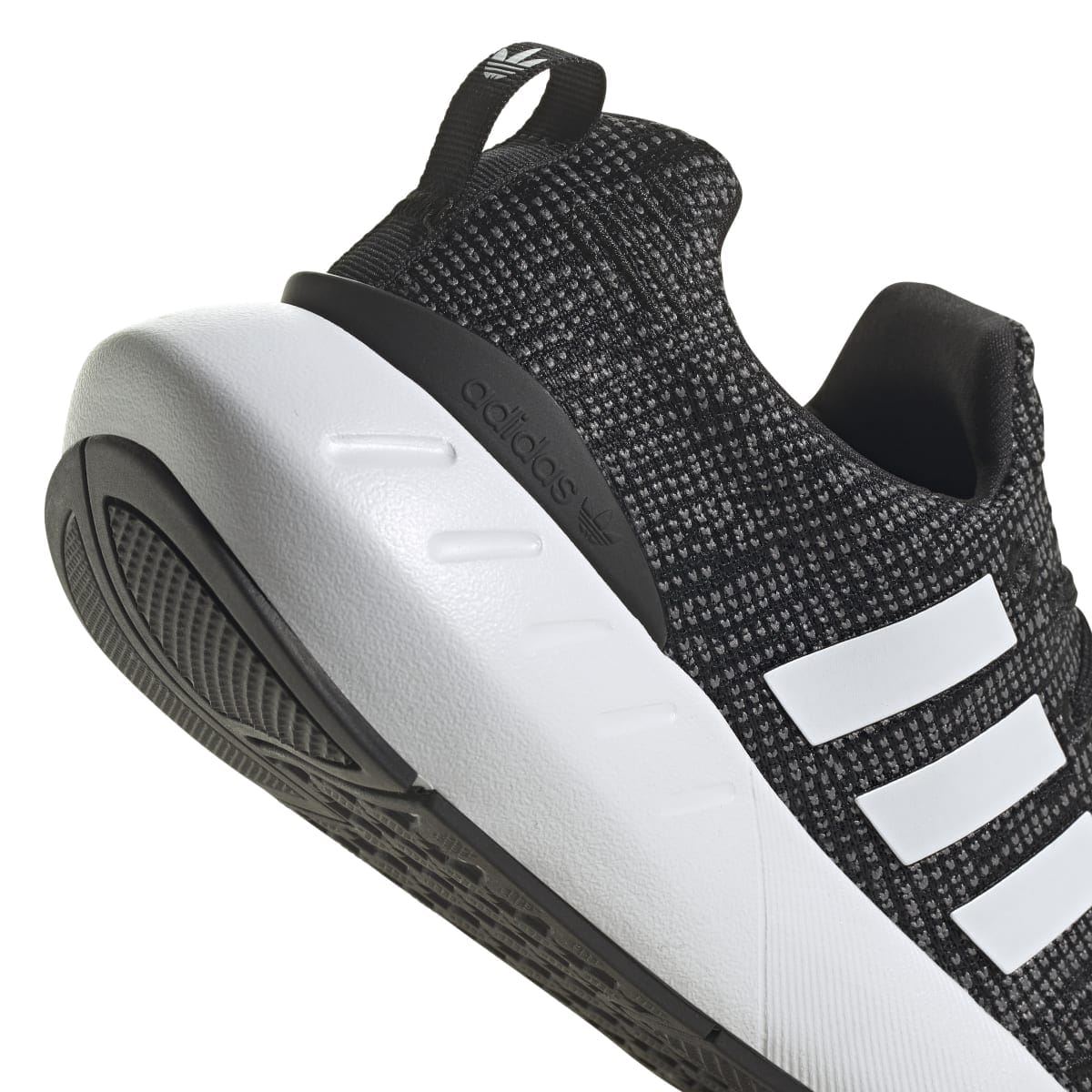 Junior adidas Swift Run 22 trainers close-up, black upper with white midsole and treaded outsole.