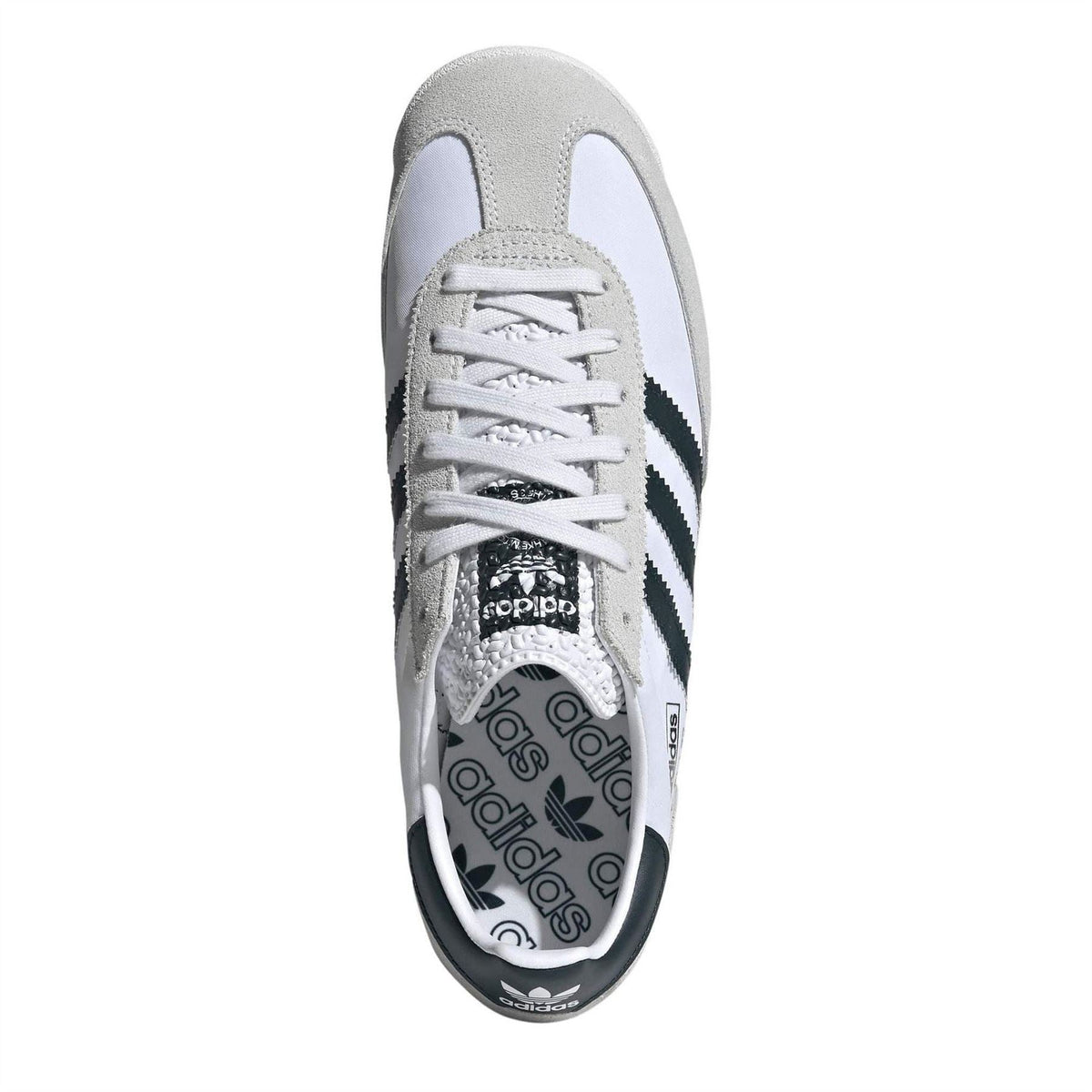 White and gray low-top sneaker with lace-up closure and black logo patch on tongue