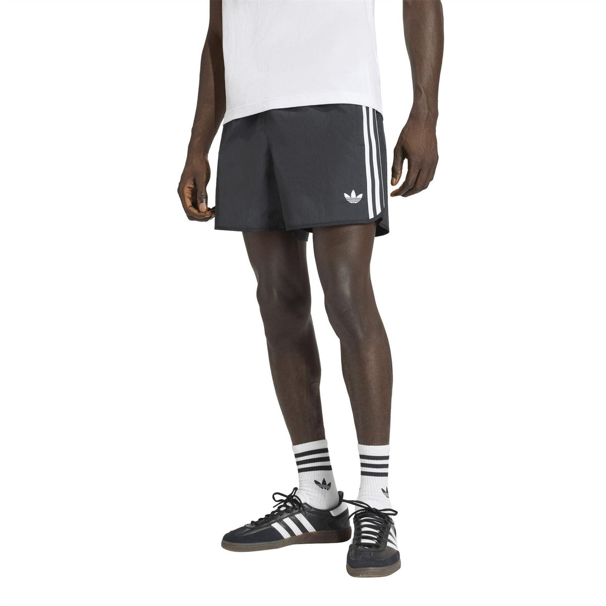 Black adidas Originals shorts on model, elastic waist and white triple side stripe detail