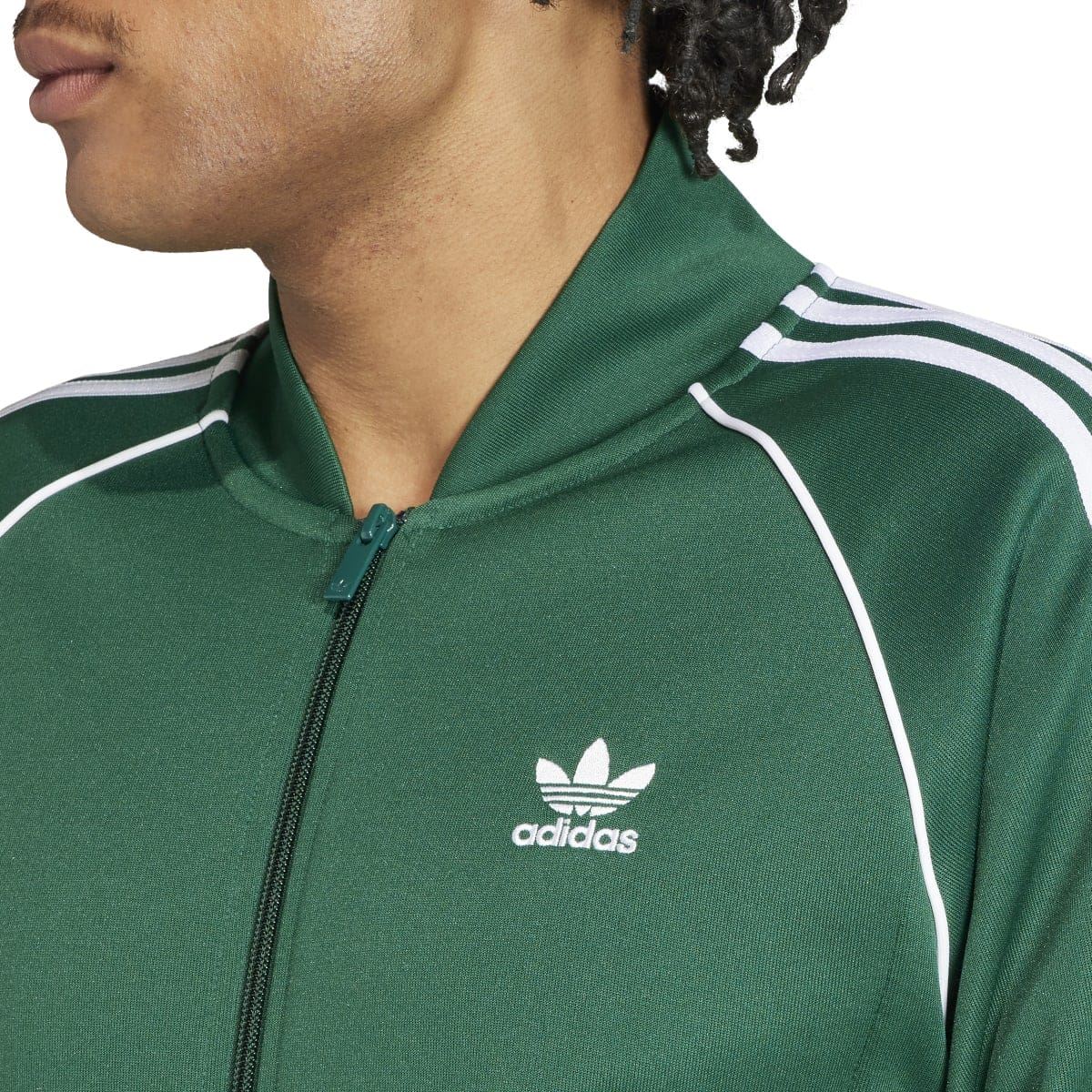 Green adidas track jacket close-up with zip front, stand collar, and adidas trefoil logo