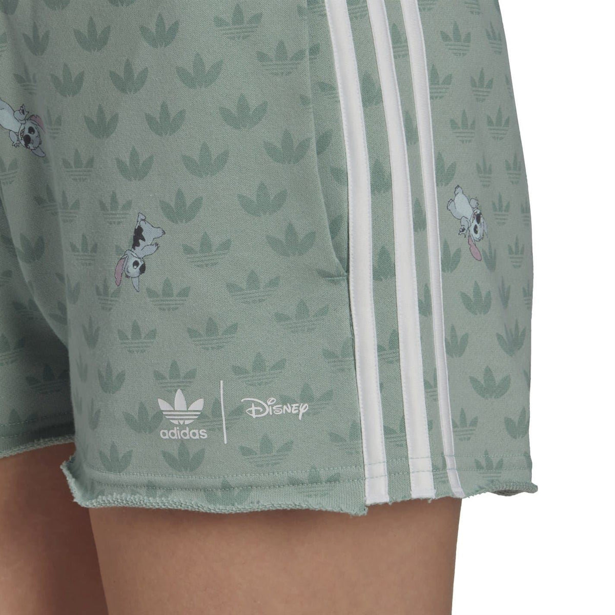 Mint green sweat shorts close-up with adidas three stripes and character-and-leaf print