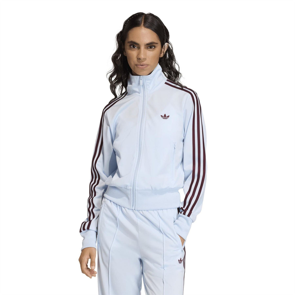 Light blue women’s track jacket with full-zip front, burgundy triple stripes, and chest logo.