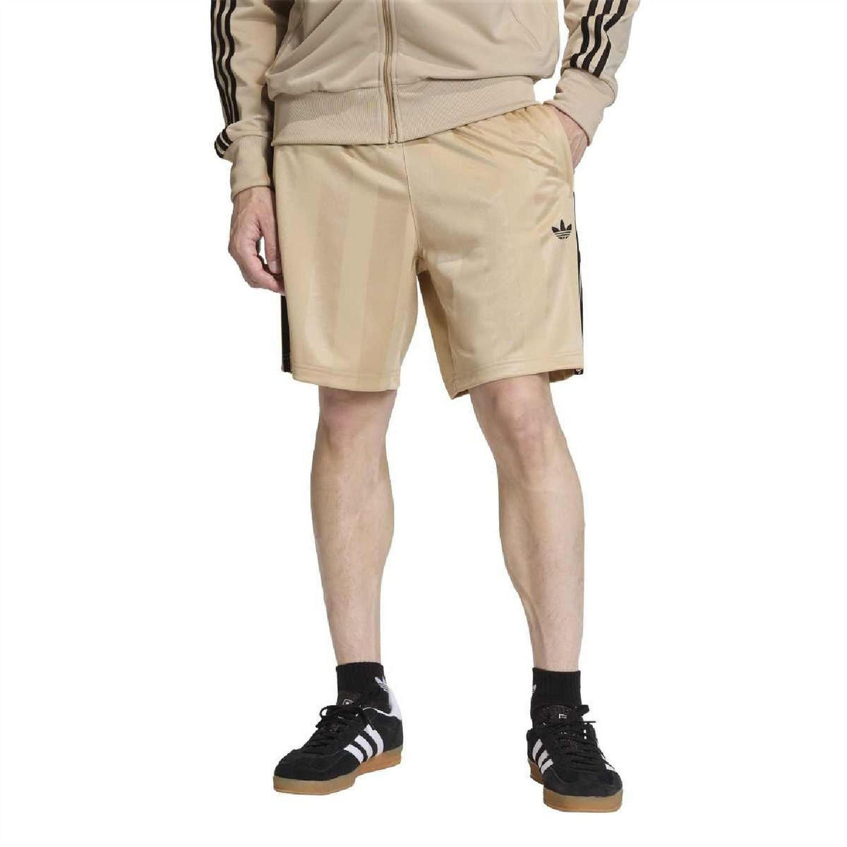 Stone khaki shorts with black side stripes and relaxed fit, worn with matching sneakers