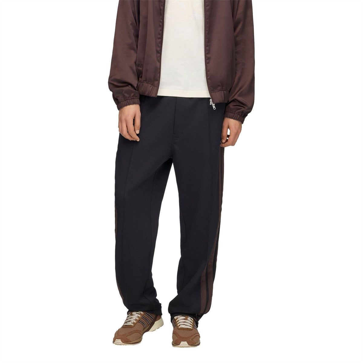 Black track pants with ankle taper and side stripe panels