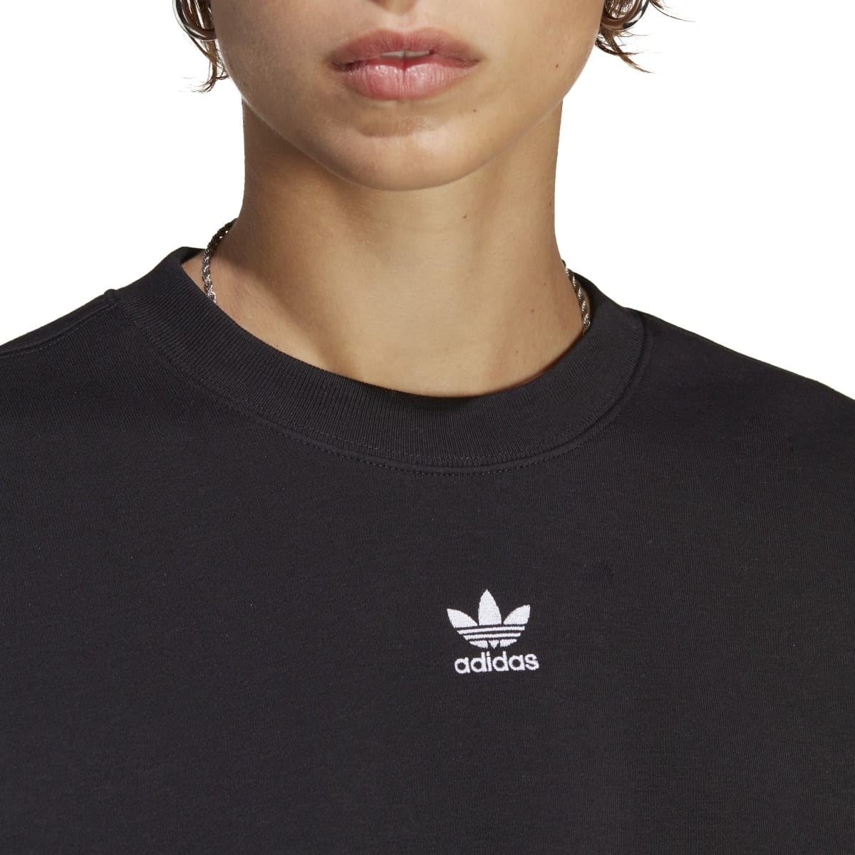 Black crewneck sweatshirt close-up with adidas Trefoil logo on chest