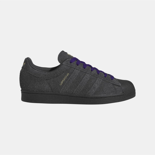 Black low-top Adidas Originals sneakers with purple laces and side stripe detail