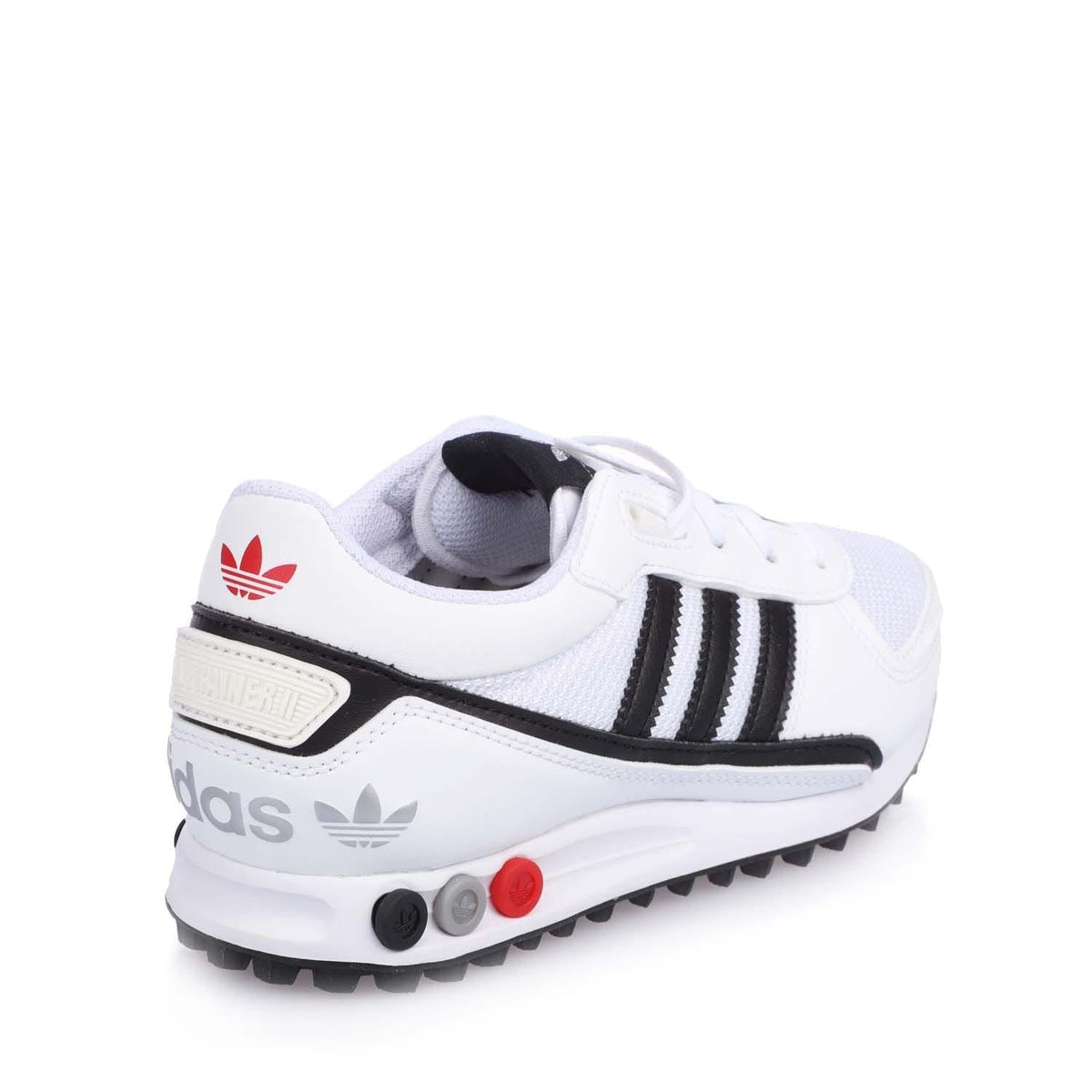 White junior Adidas LA Trainer II with raised heel logo and black strap detail.