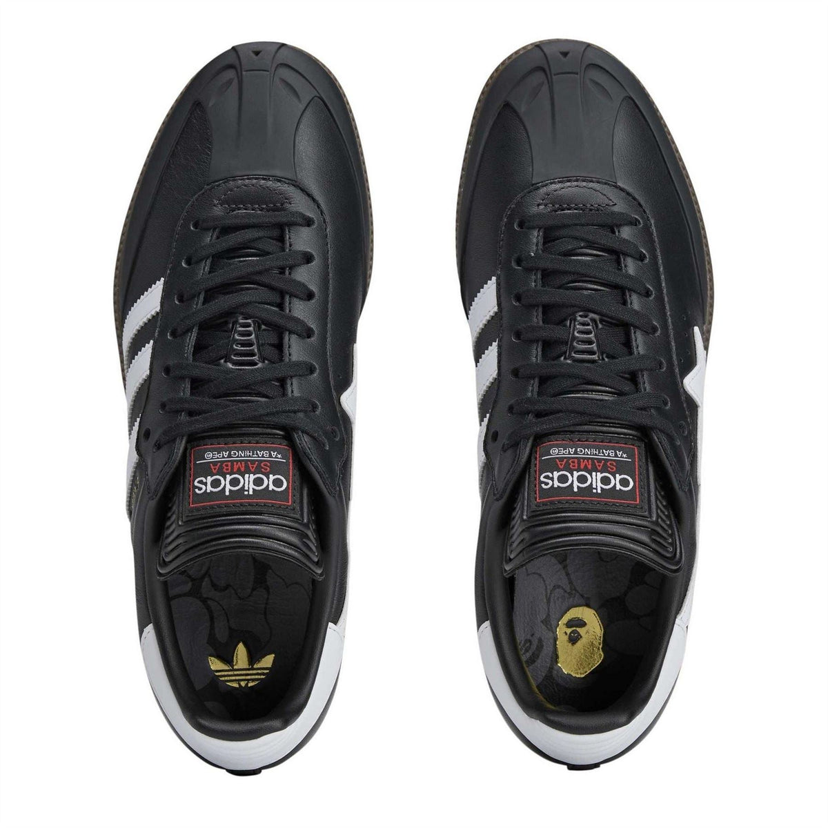 Black low-top sneakers with black laces, white side stripes, and printed insole