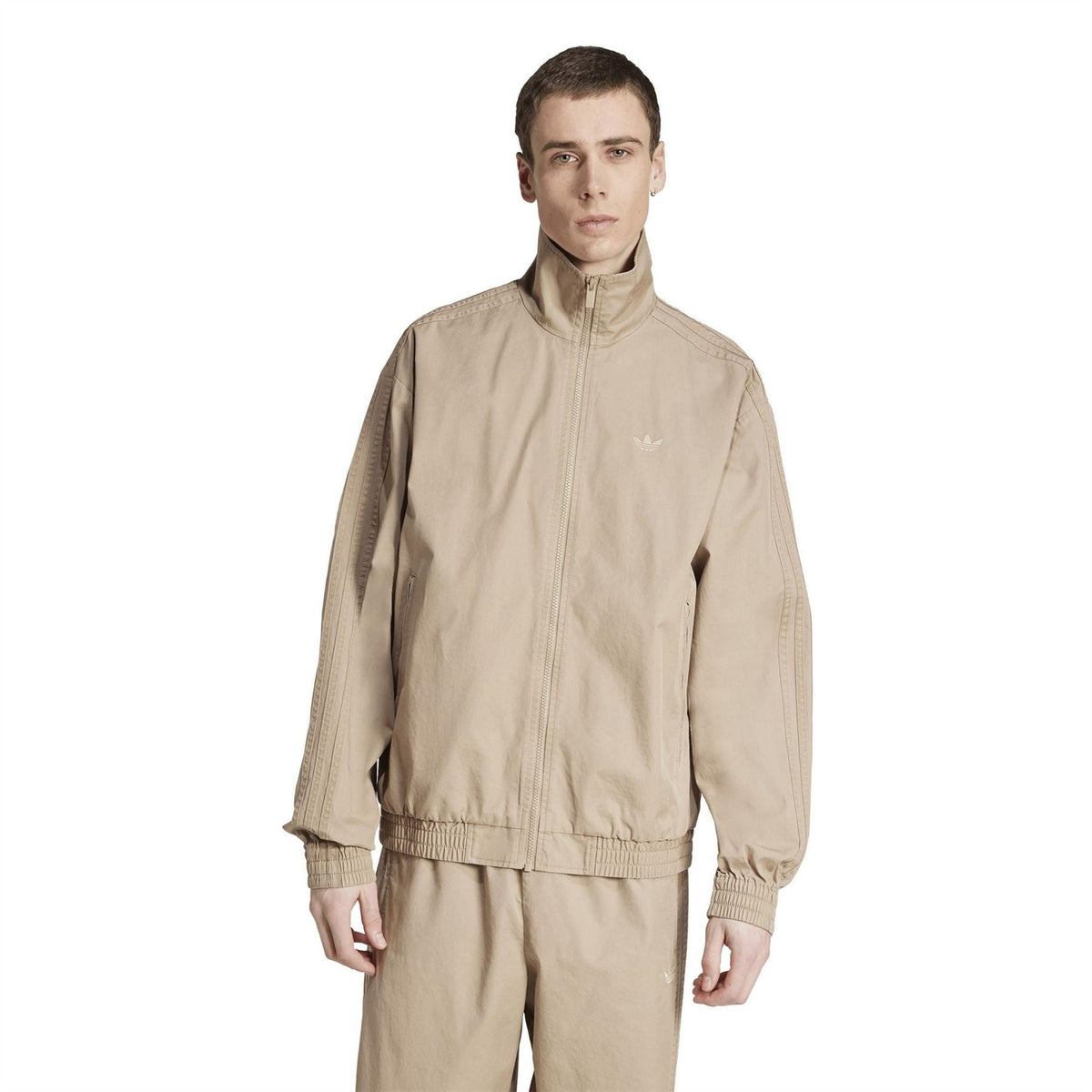 Tan track jacket with full front zipper, stand collar, and elastic cuffs