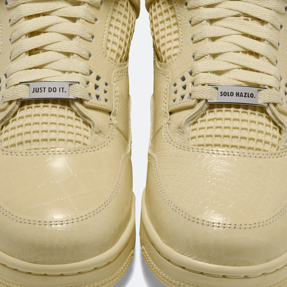 Close-up of yellow sneaker laces and side panels with printed 'JUST DO IT.'