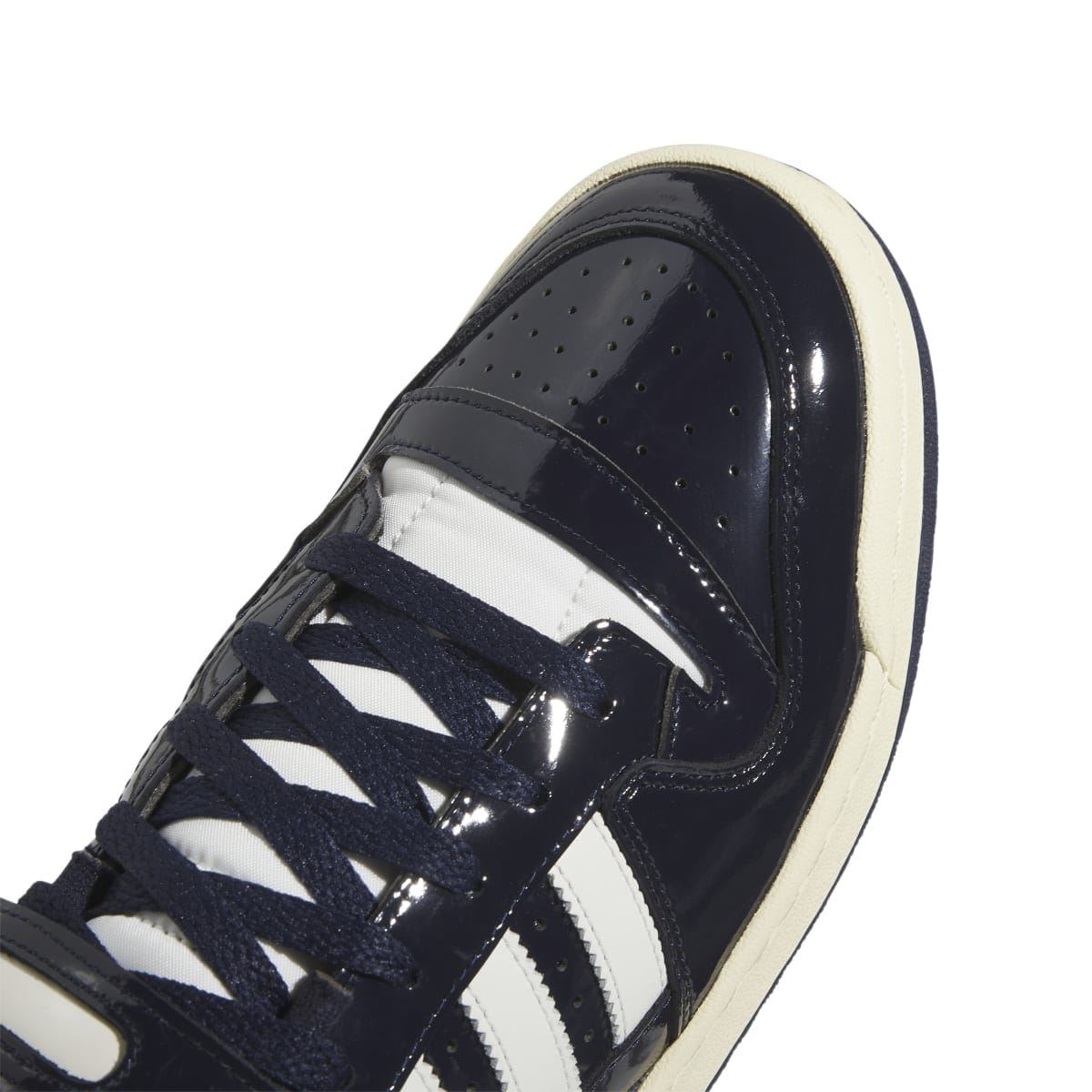 Close-up of dark navy adidas sneaker upper with white stripe details and lace-up eyelets