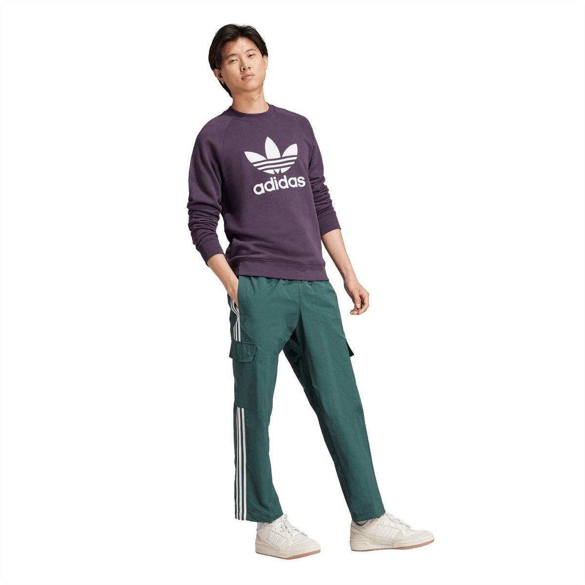 Dark purple adidas Trefoil crew sweatshirt on model with green track pants.