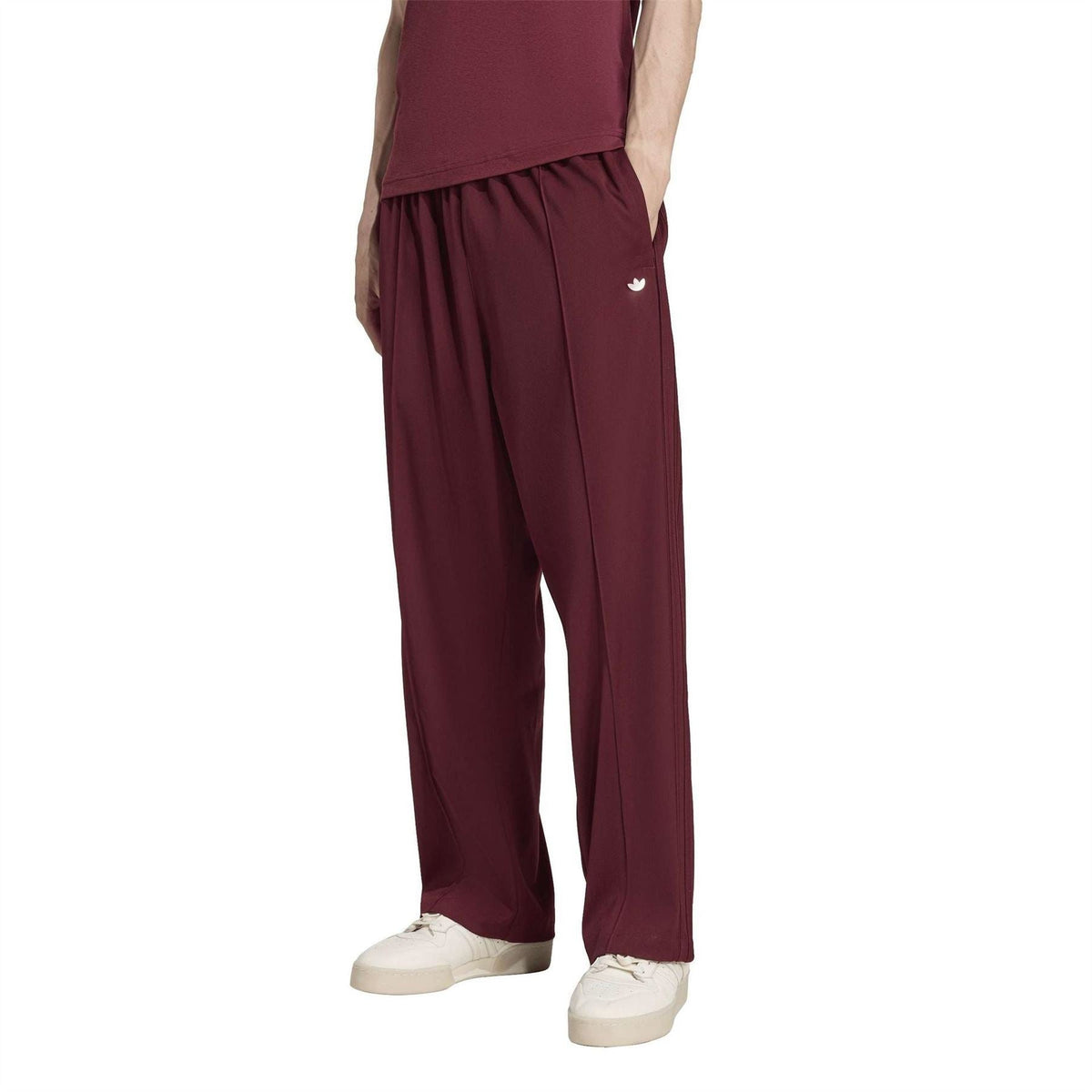 Maroon baggy track pants with adidas logo on thigh and relaxed straight-leg fit