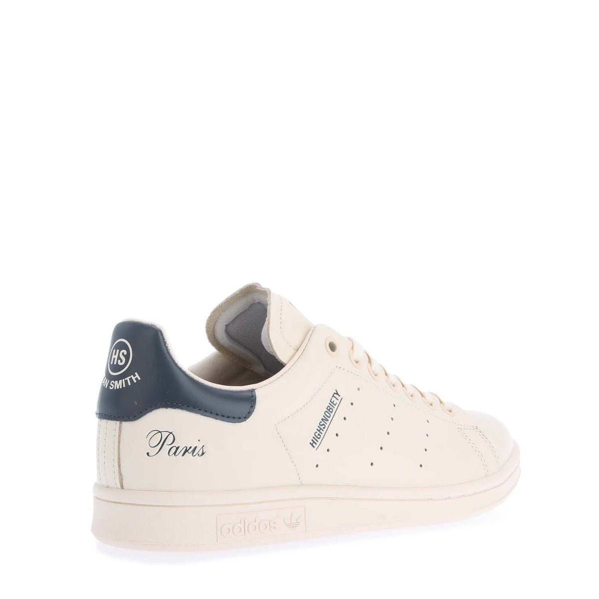 White high-top sneakers with navy collar and “Paris” script on the side panel.