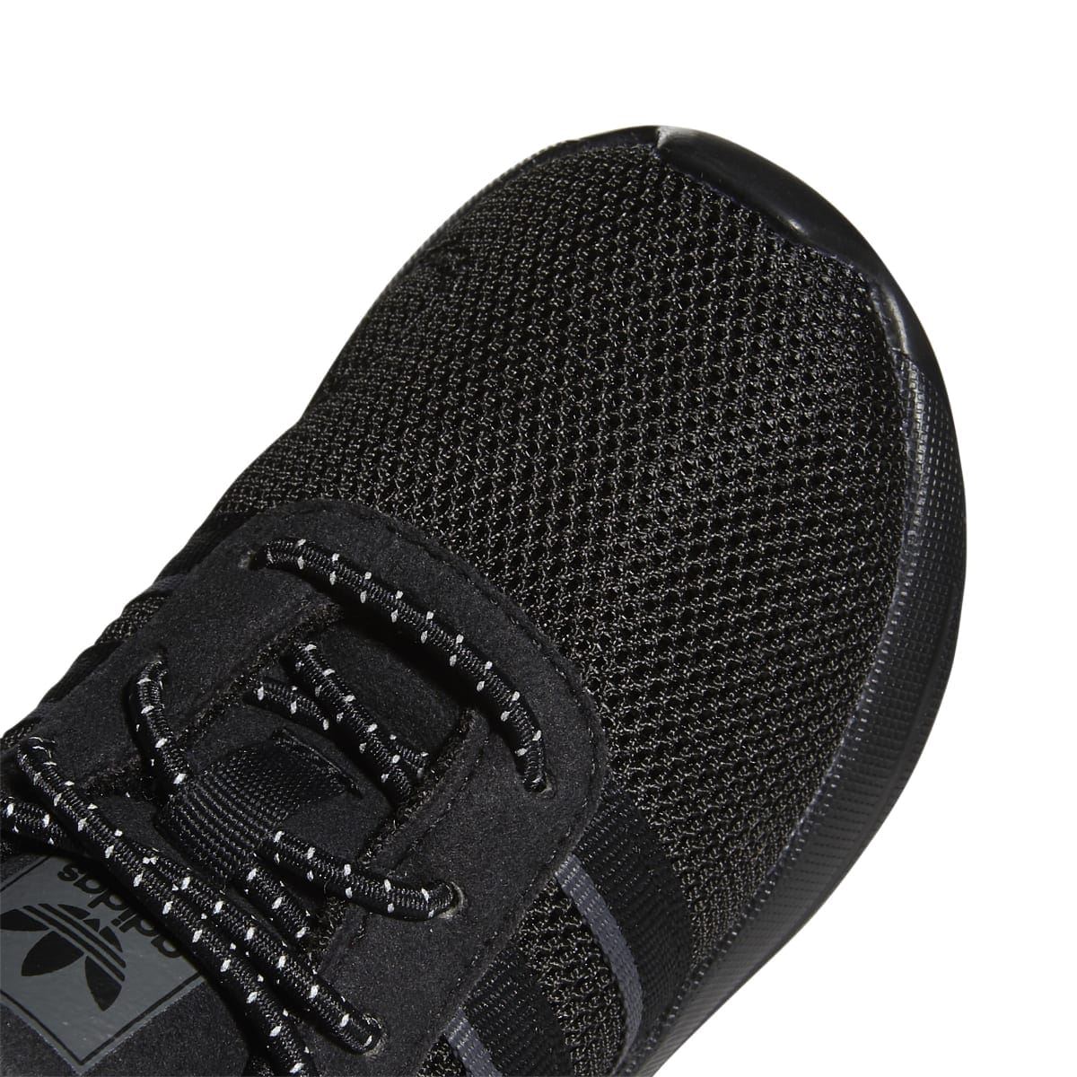 Infant trainer toe close-up with black mesh, lace-up panel, and gray stripe.