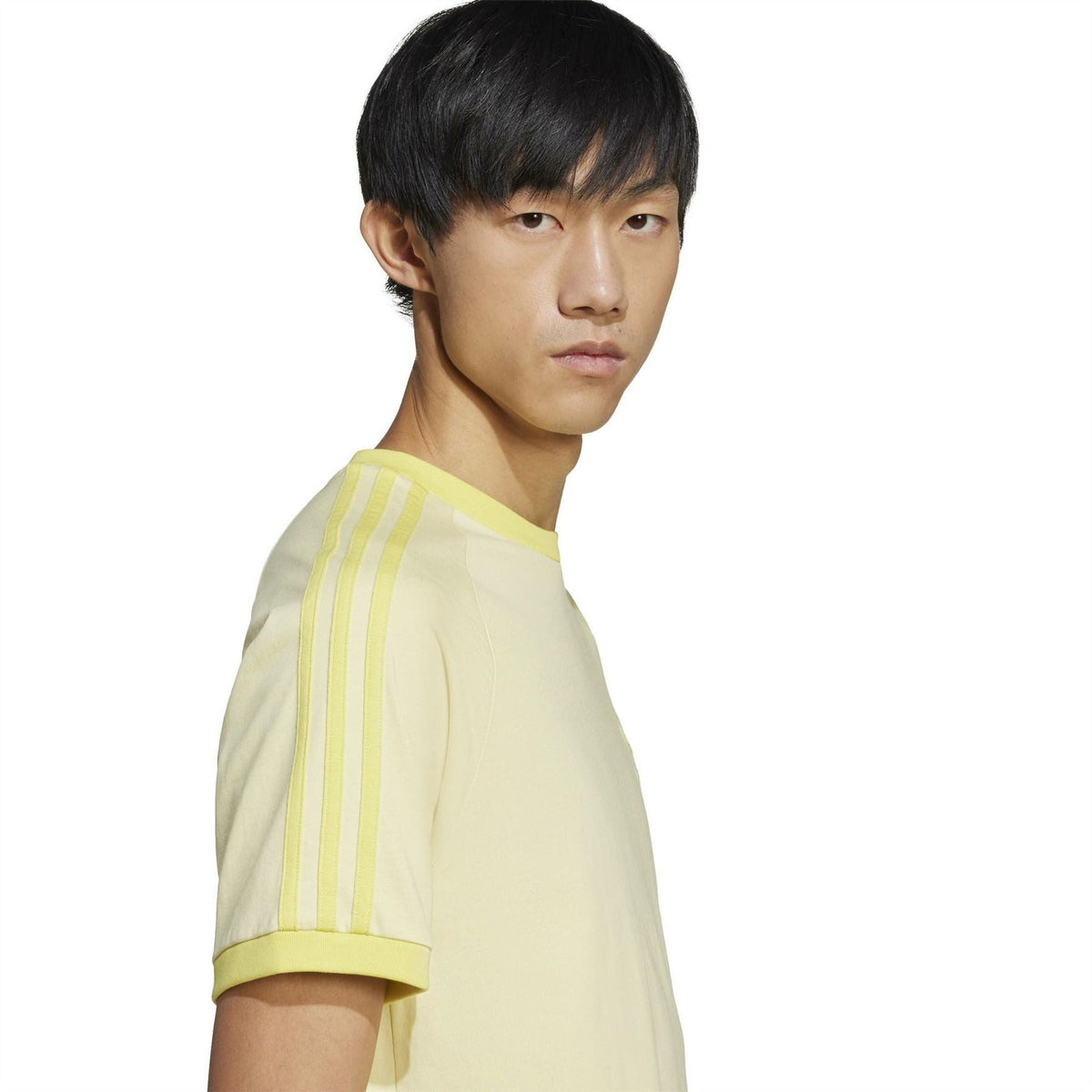 Light yellow raglan T-shirt close-up with 3-stripe sleeve panel and adidas Originals logo