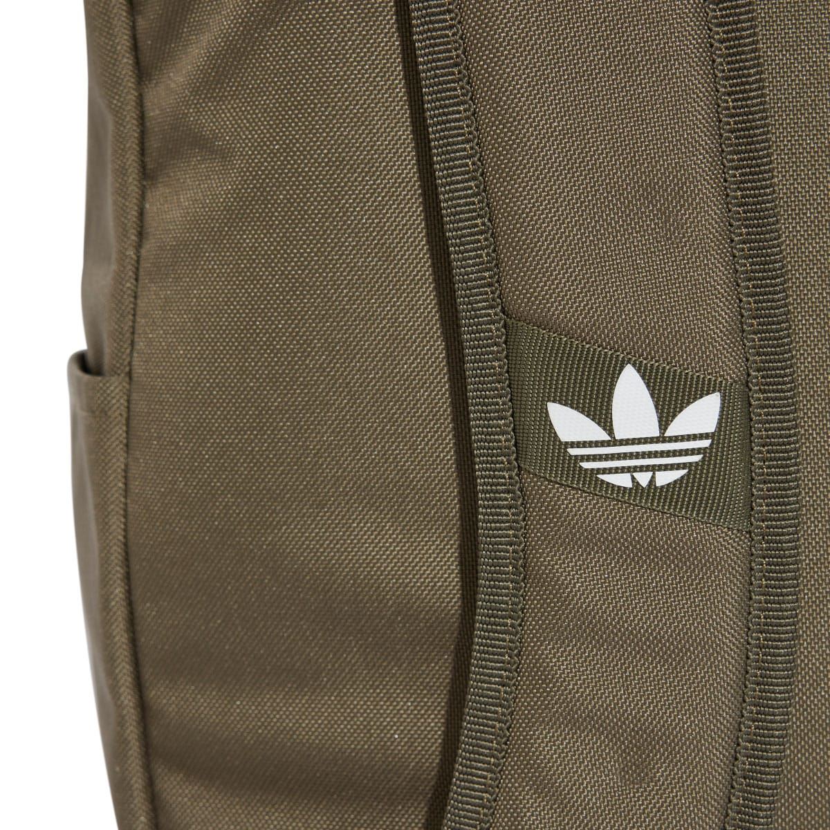 Olive backpack front panel close-up with white adidas trefoil logo and stitched seams