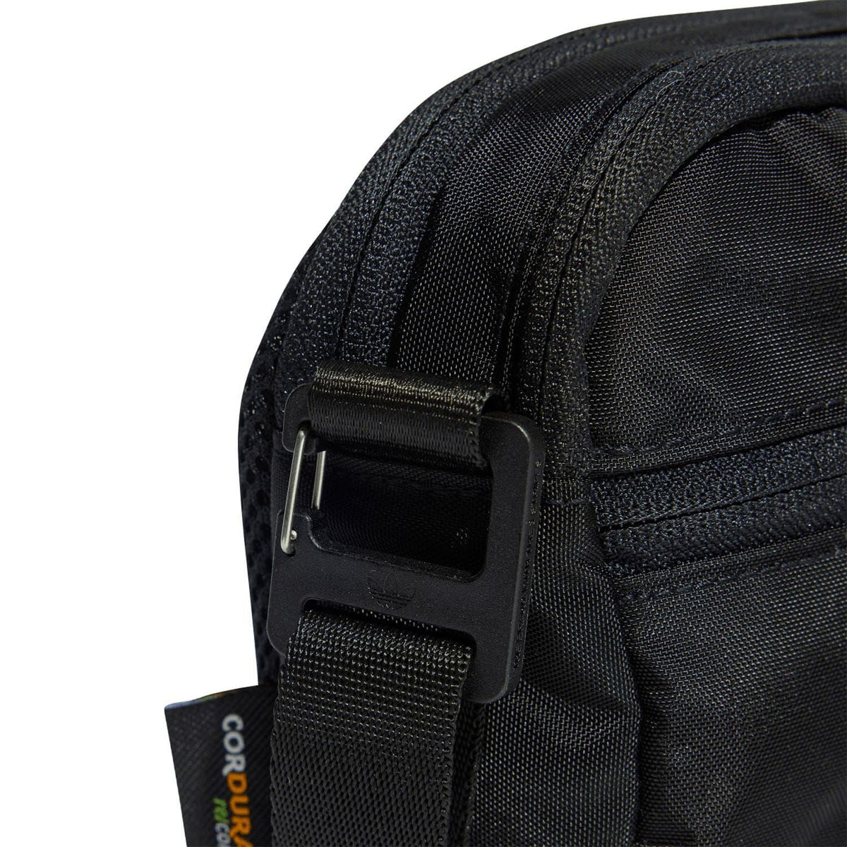 Black bag close-up: webbing strap with metal buckle and zipper