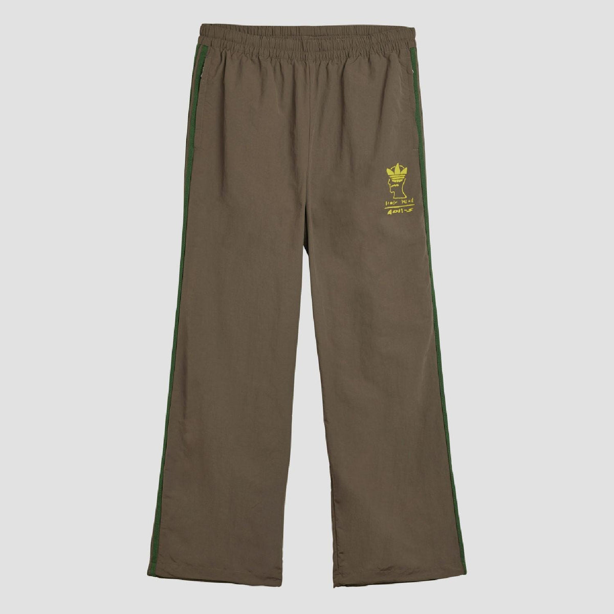 Chocolate track pants with elastic waist and green side stripes, yellow logo print