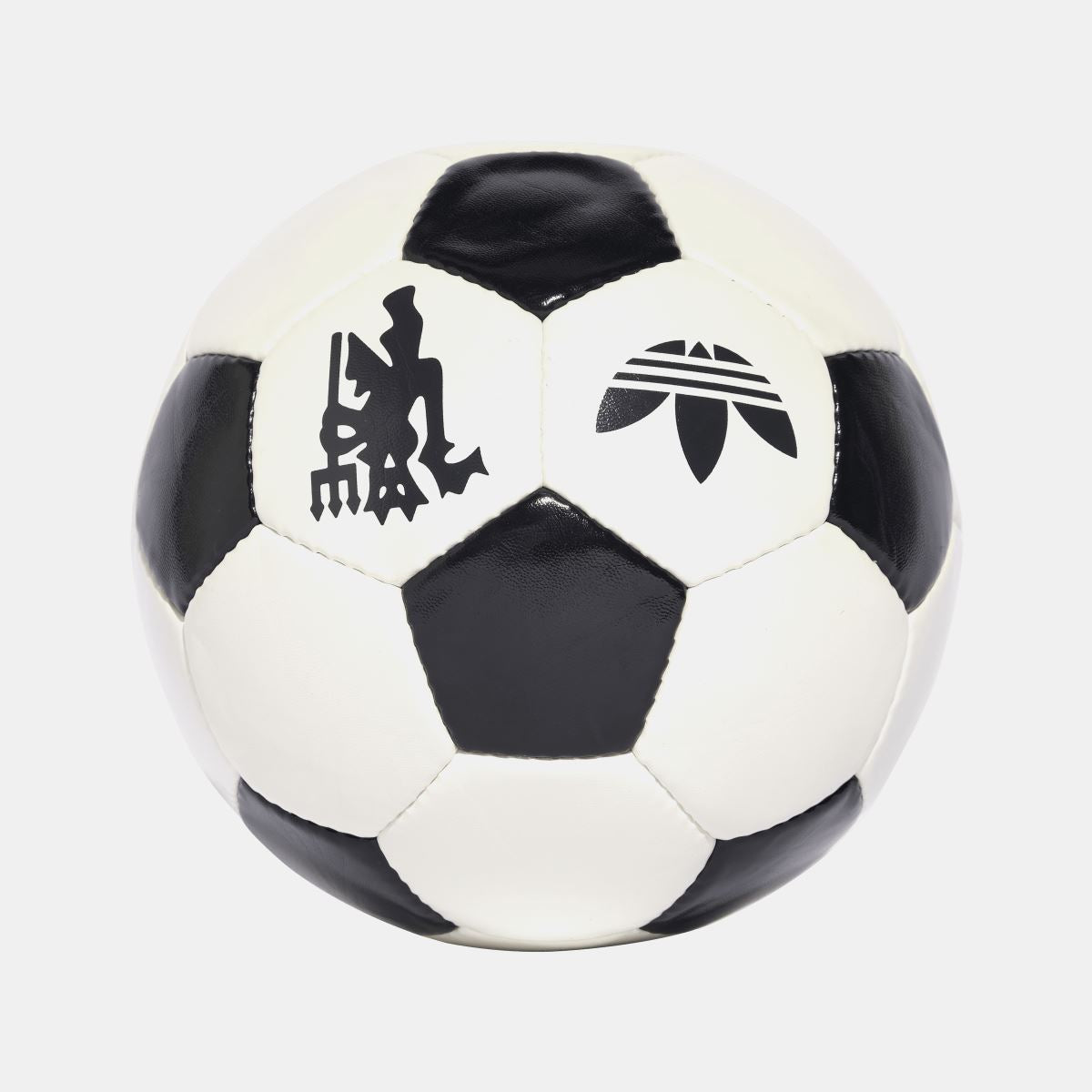 Off-white and black soccer ball showing trefoil and club crest on panels