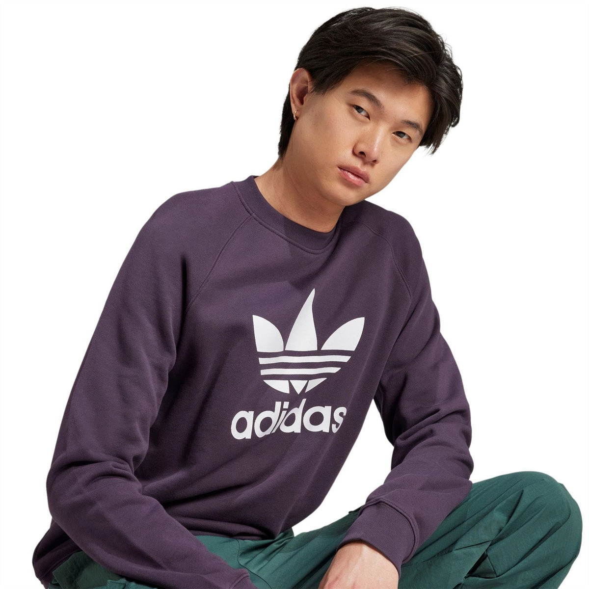 Dark purple crew sweatshirt with large adidas Trefoil logo and adidas text, front close-up.