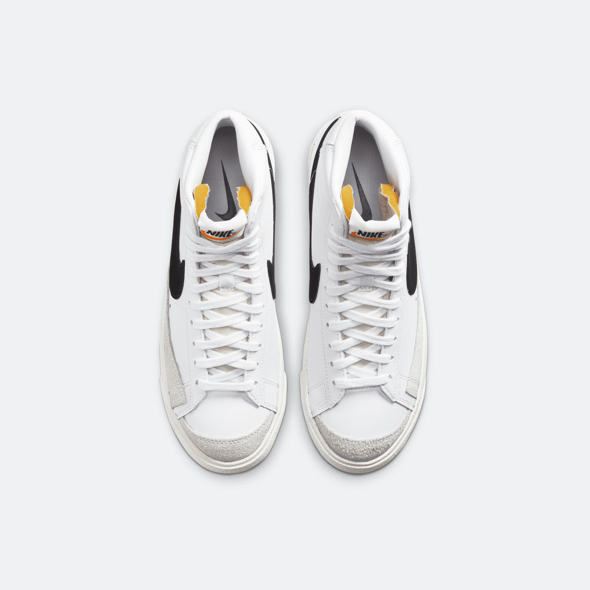 White Nike Blazer Mid '77 sneakers with white laces and black side swoosh