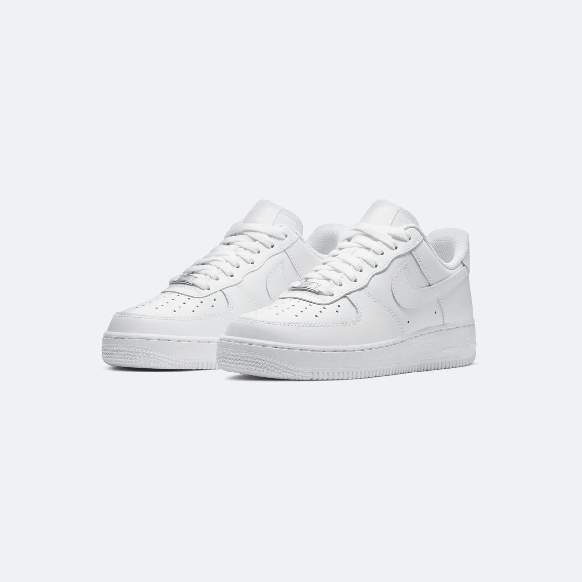 White Nike Air Force 1 low-top sneakers, pair view with lace-up and swoosh