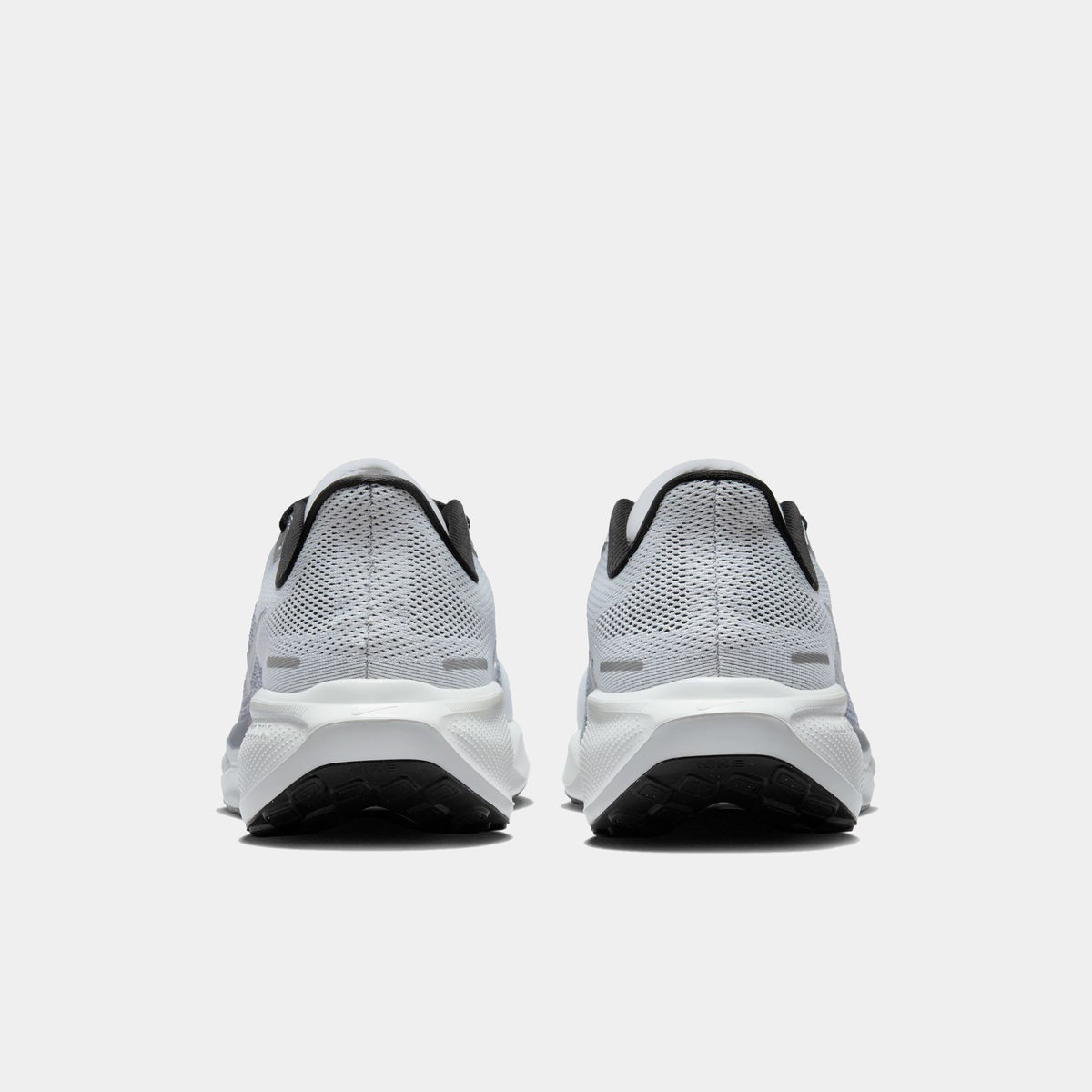 Light gray running shoes rear view with black heel lining and white cushioned sole