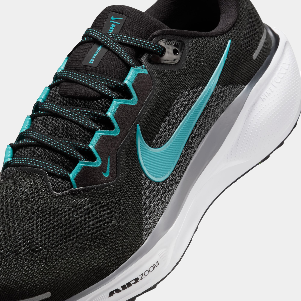 Air Zoom Pegasus 41 close-up: black knit upper with teal eyelets and Air Zoom midsole