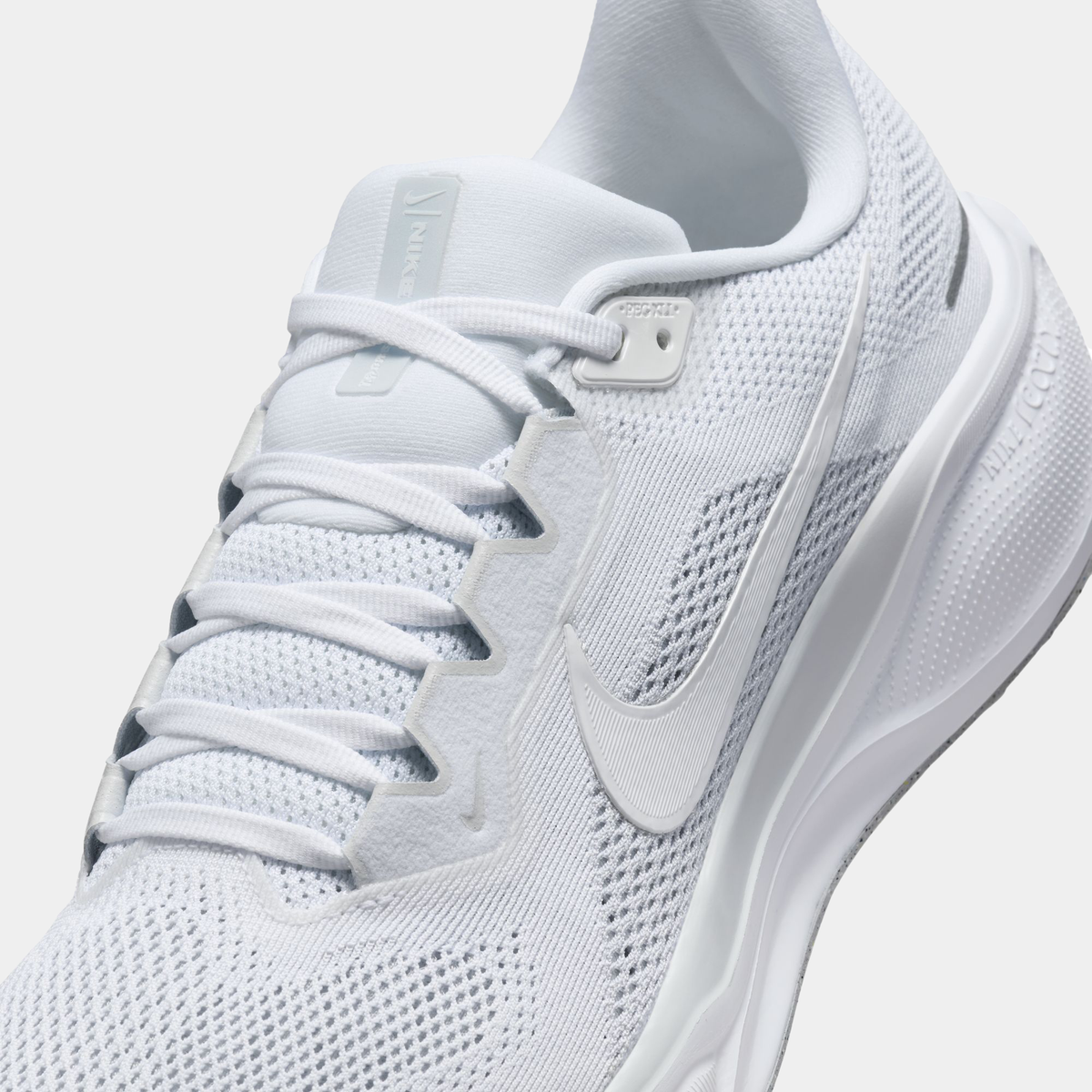 White lace-up running shoe upper with mesh texture and swoosh on side