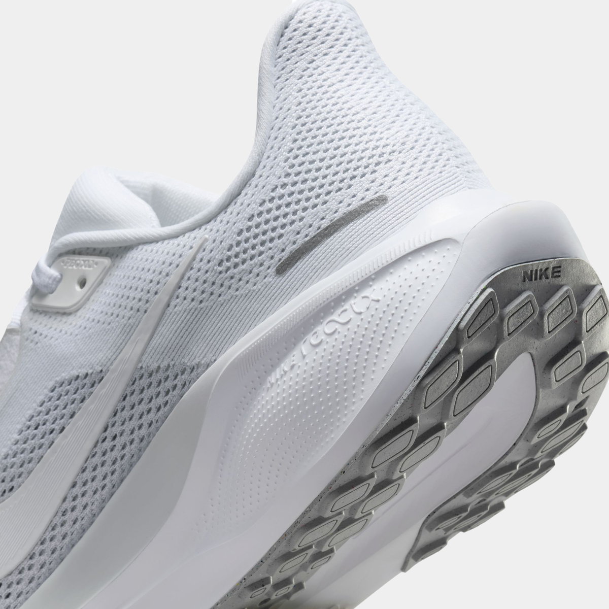 Close-up of white running shoe heel and outsole tread with logo label