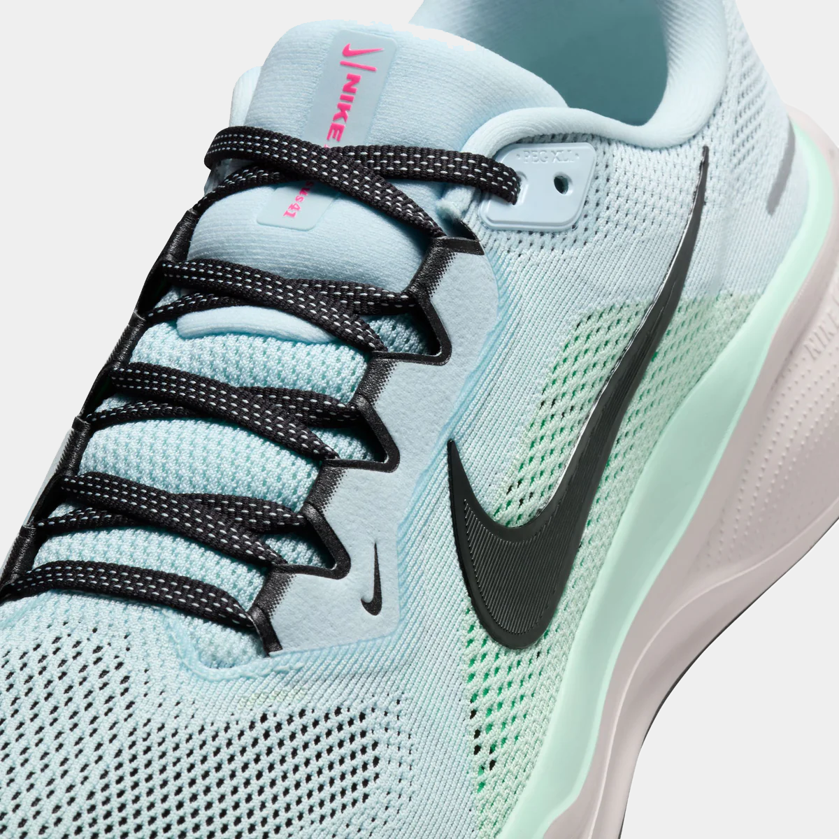 Close-up of light blue running shoe upper with black lace overlay and swoosh