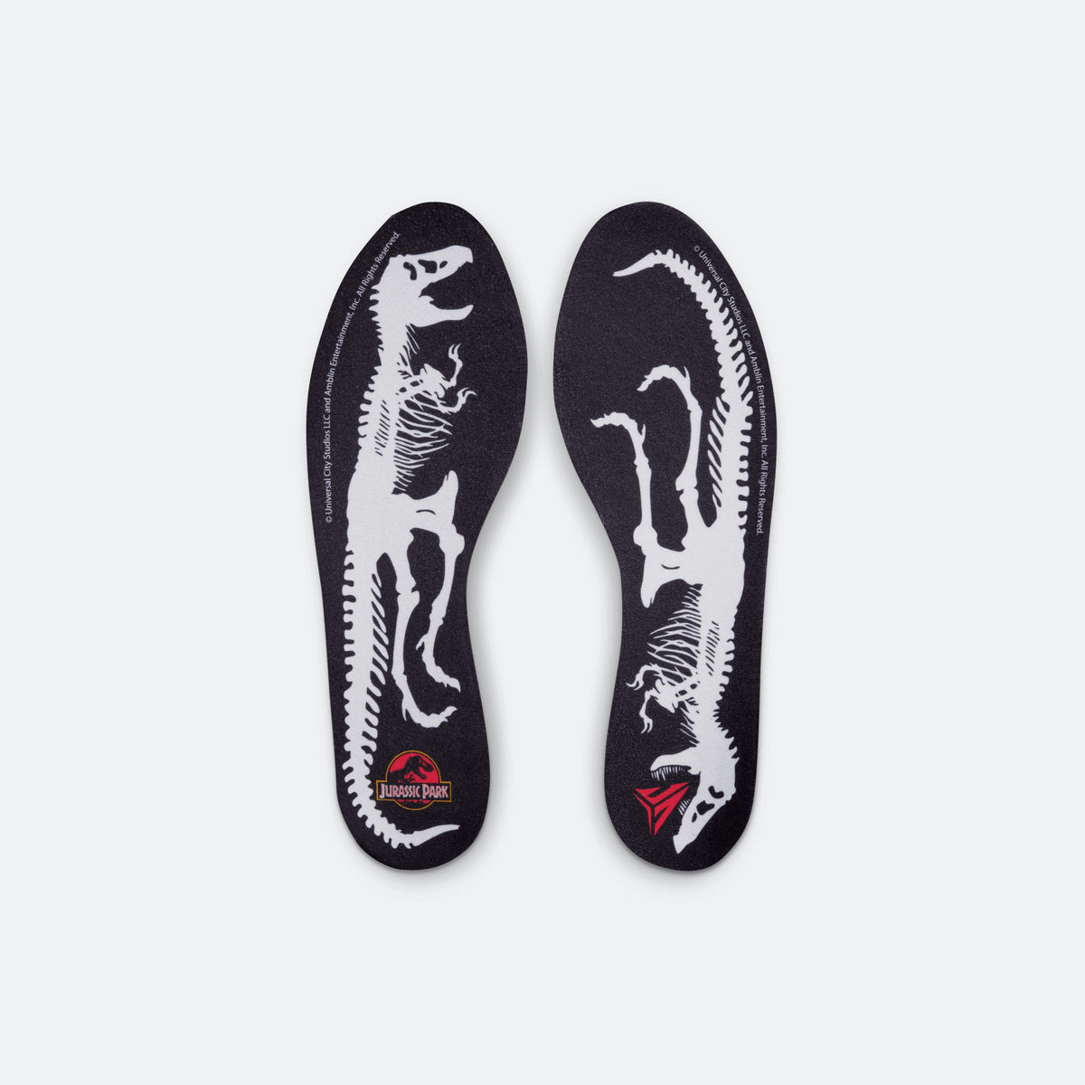 Pair of black insoles with white dinosaur graphics and red Jurassic Park badge