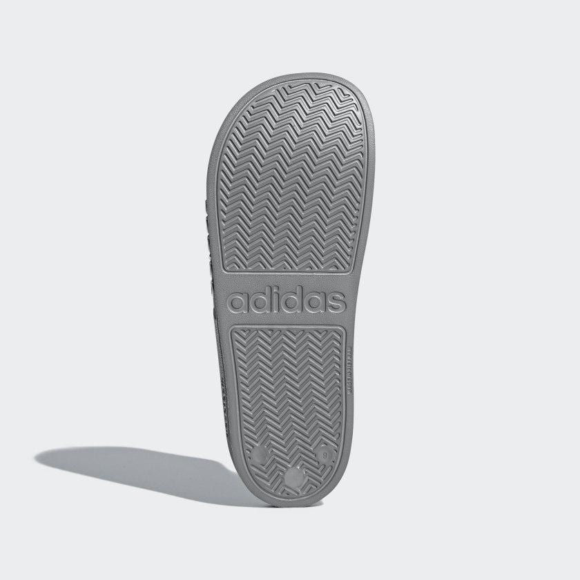 Adilette shower slides gray outsole with textured chevron pattern and adidas logo