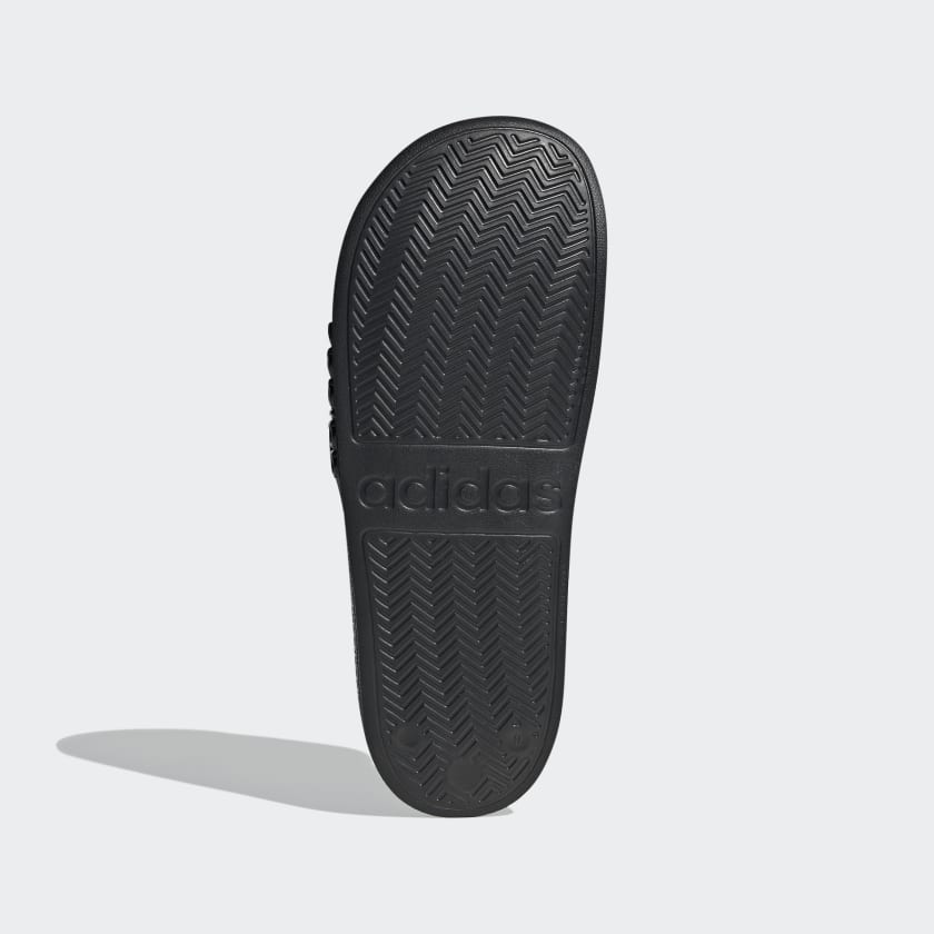 Black adidas slide sandals outsole with chevron tread pattern