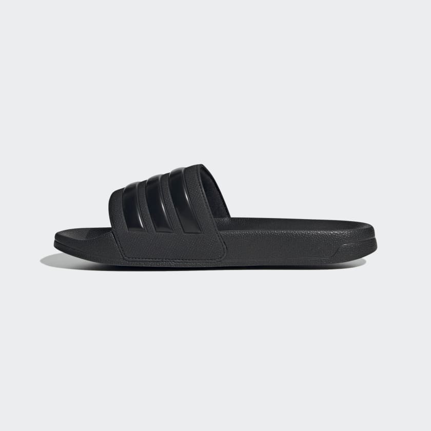 Black slide sandals with triple stripes on upper and flat molded sole