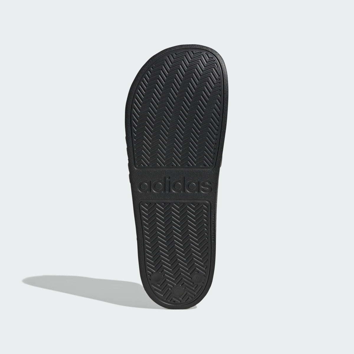 Black slide sandal outsole with adidas logo and zigzag tread