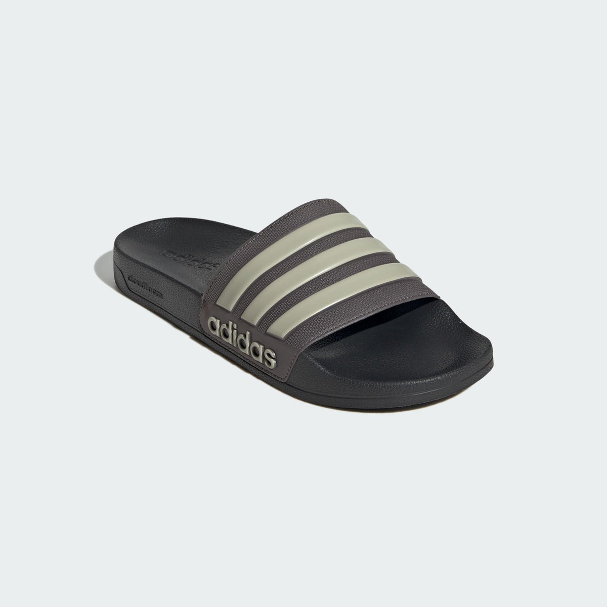 Dark shower slide sandals with adidas logo and three light beige stripes