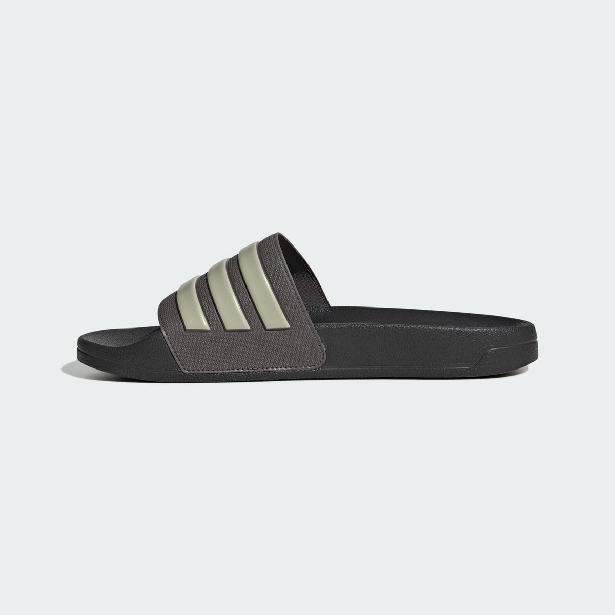 Brown shower slide sandals with adidas logo and three cream stripes