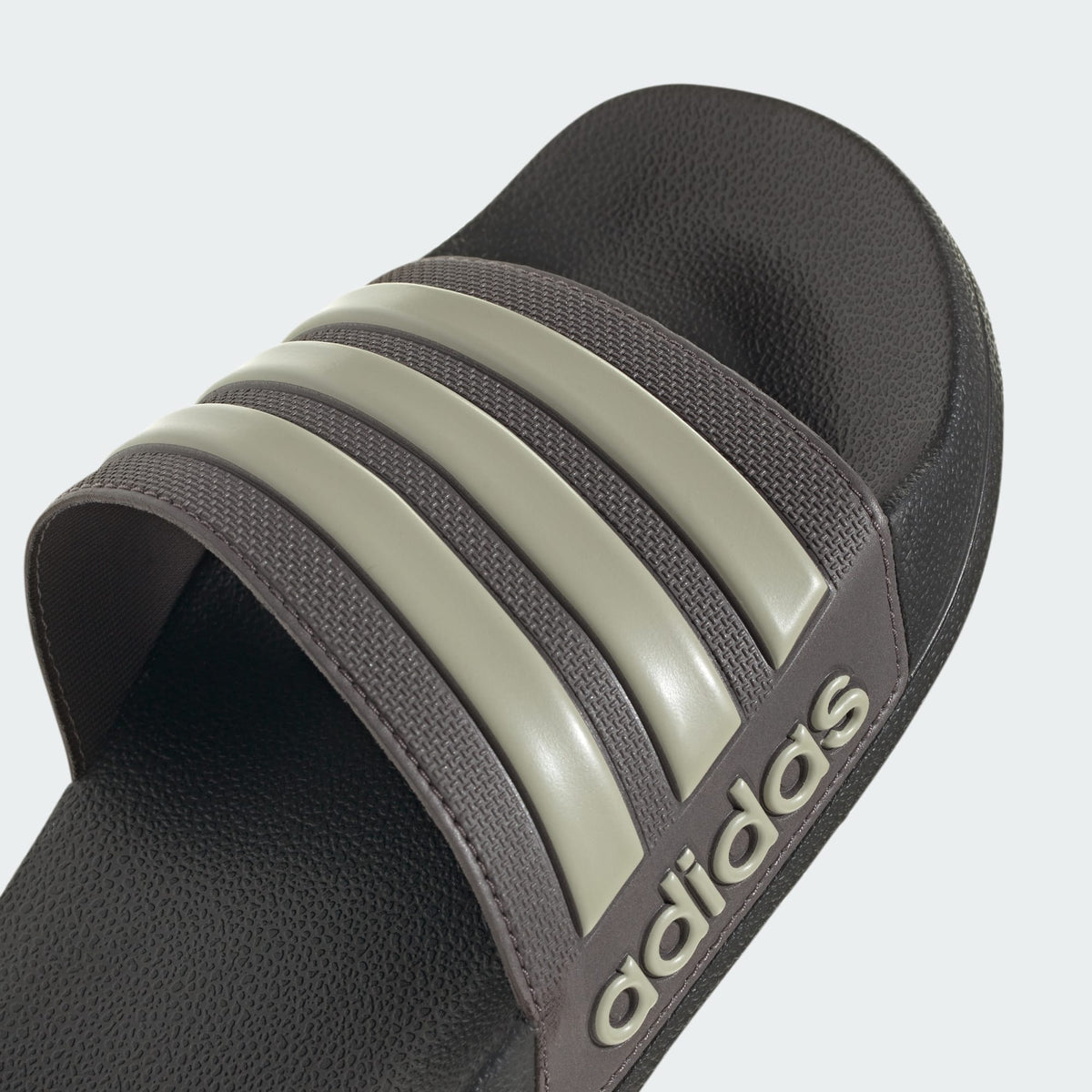 Dark slide sandal with three light stripes and adidas logo on the side