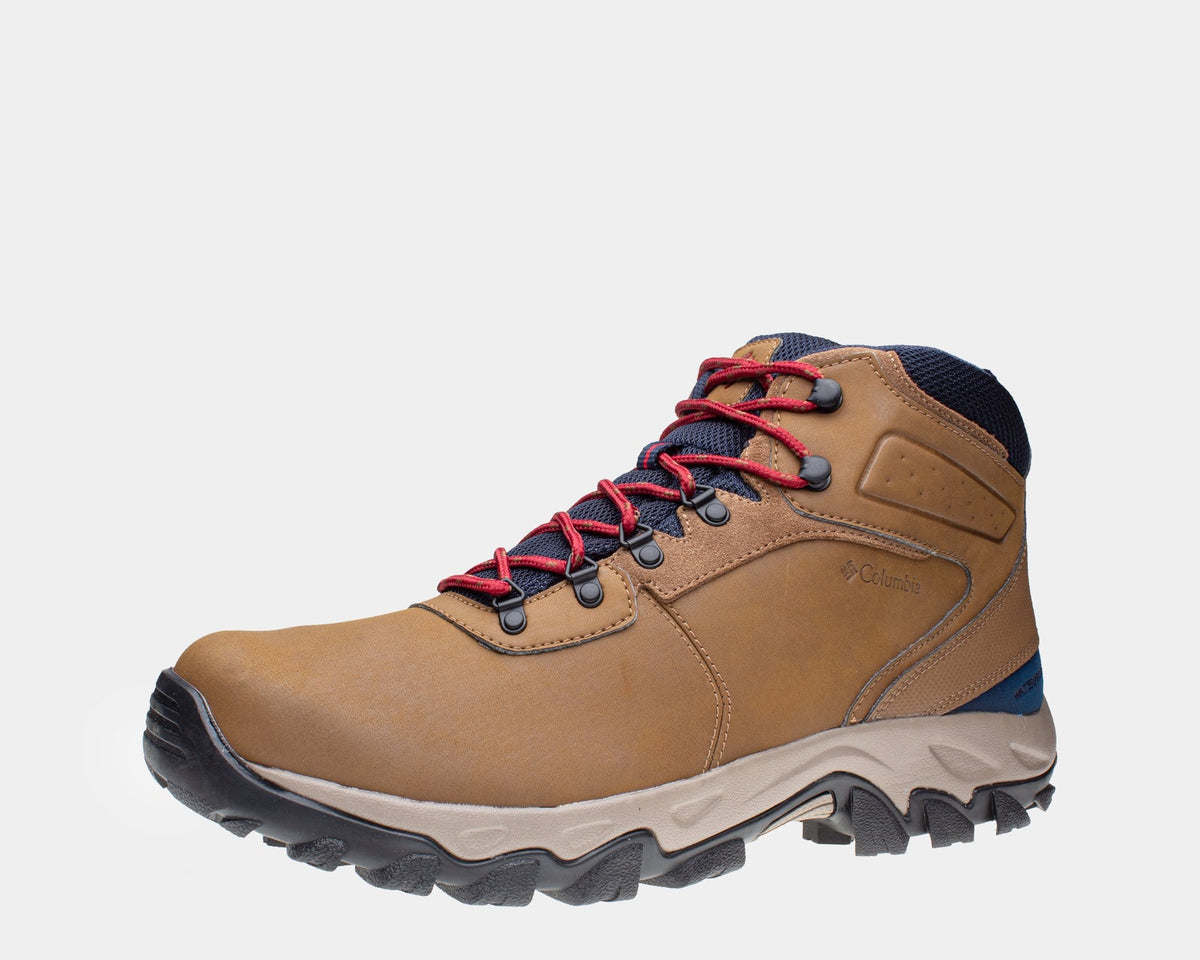 Tan waterproof hiking boots with red laces, navy ankle panel, and gray lug sole