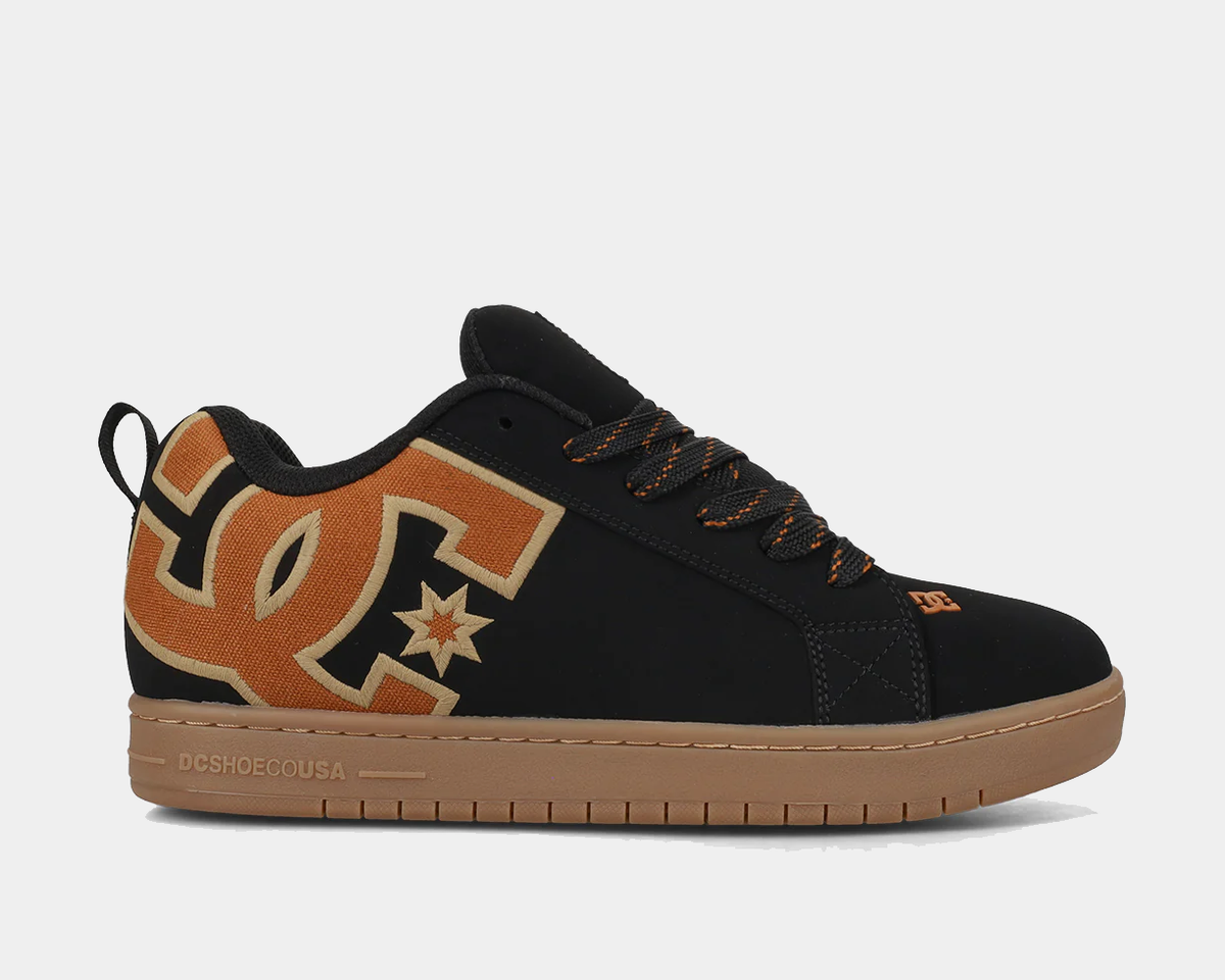 Black low-top sneakers with tan DC star print, orange laces, gum rubber sole
