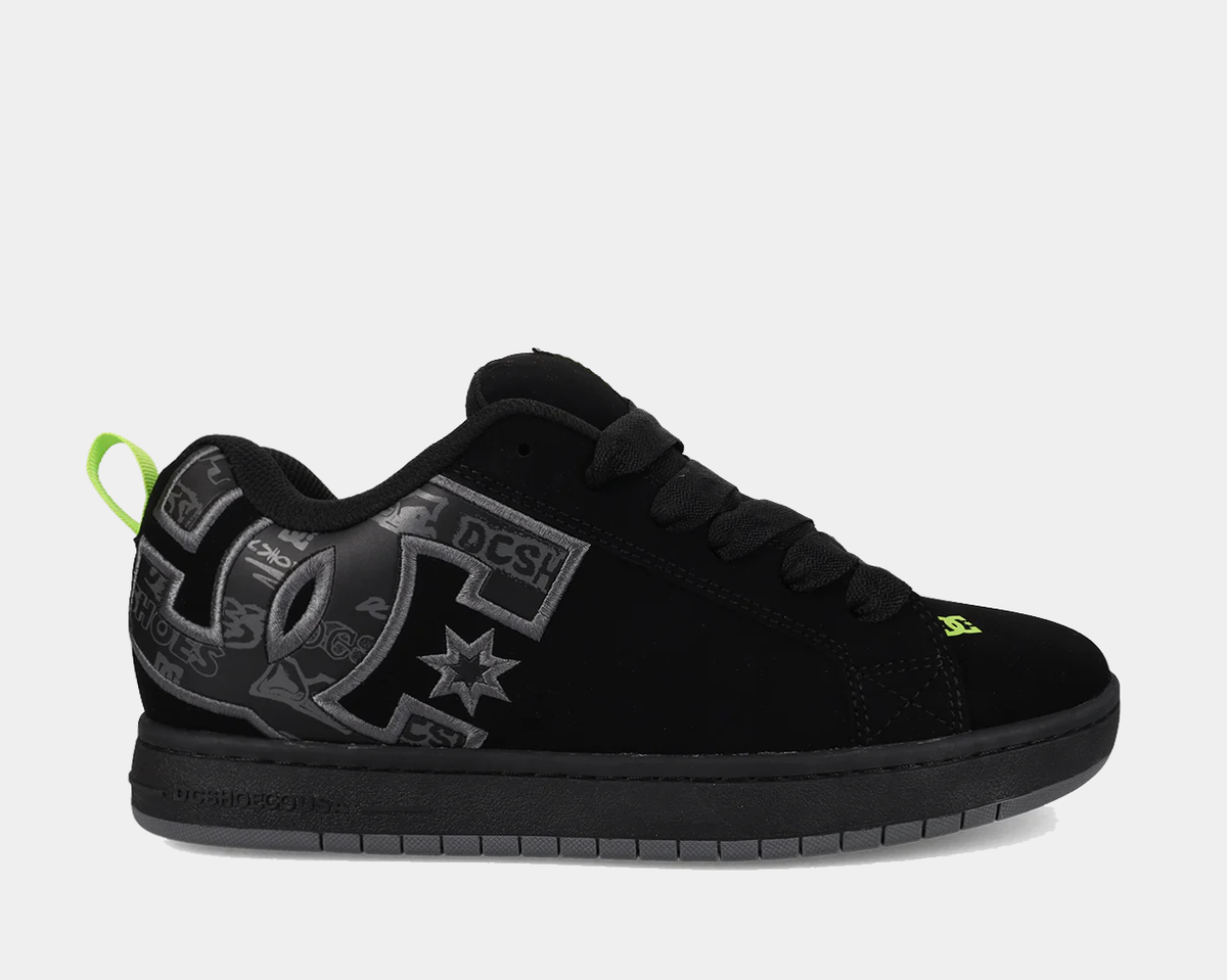Black low-top sneakers with gray DC-style print and neon green pull tab
