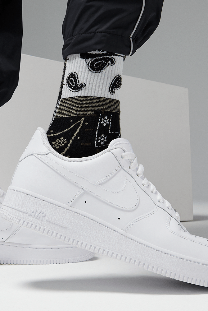 Close-up of white Nike low-top sneakers with swoosh, laces, and AIR text