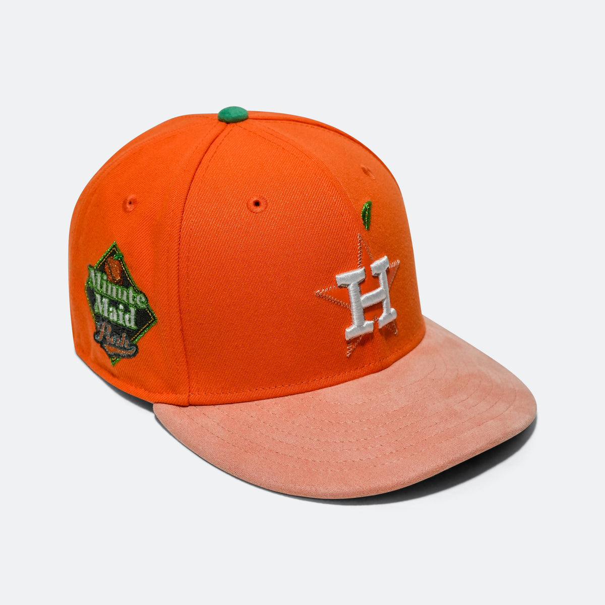 Orange baseball cap with pink brim, silver 'H' logo, and green 'Minute Maid Park' patch