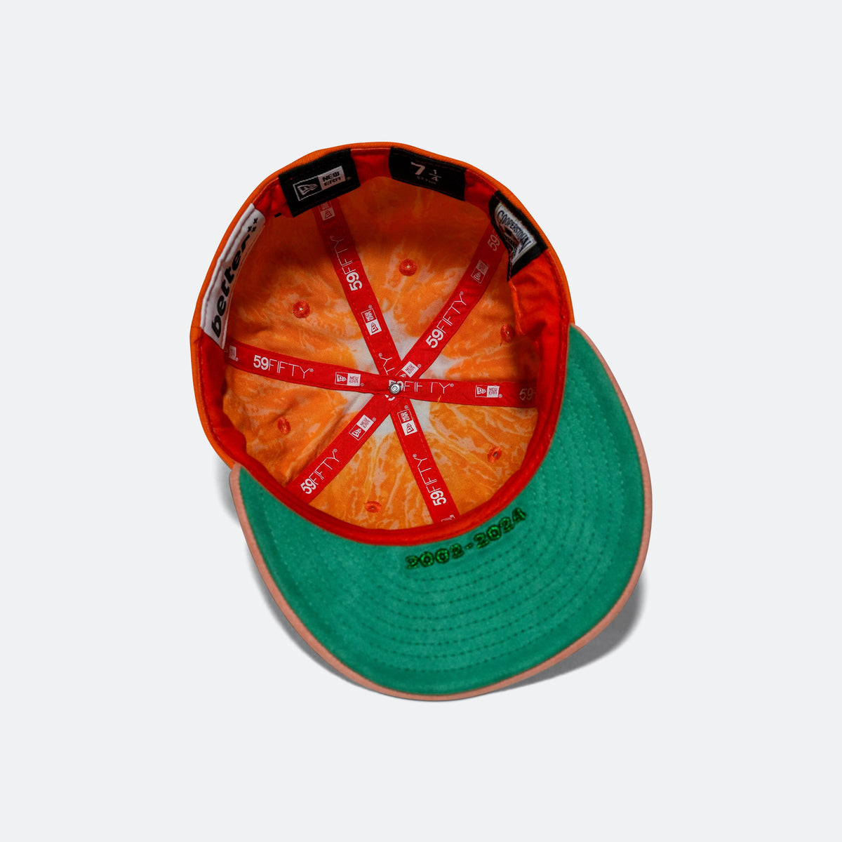 Orange interior baseball cap with green under brim and printed 59FIFTY label