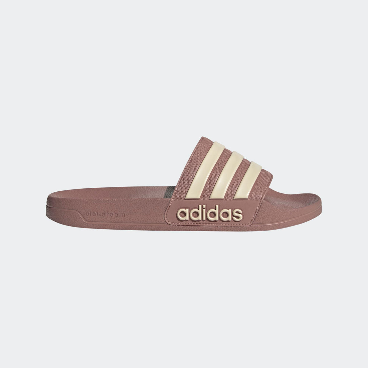 Brown shower slide sandals with adidas logo and three cream stripes